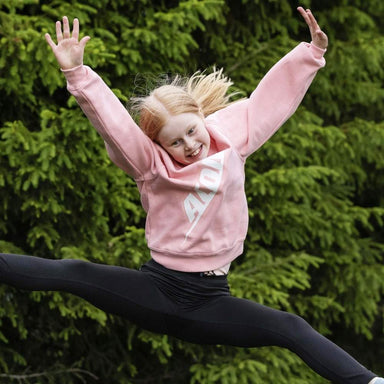 A happy girl in an Acon shirt jumping on a trampoline.
